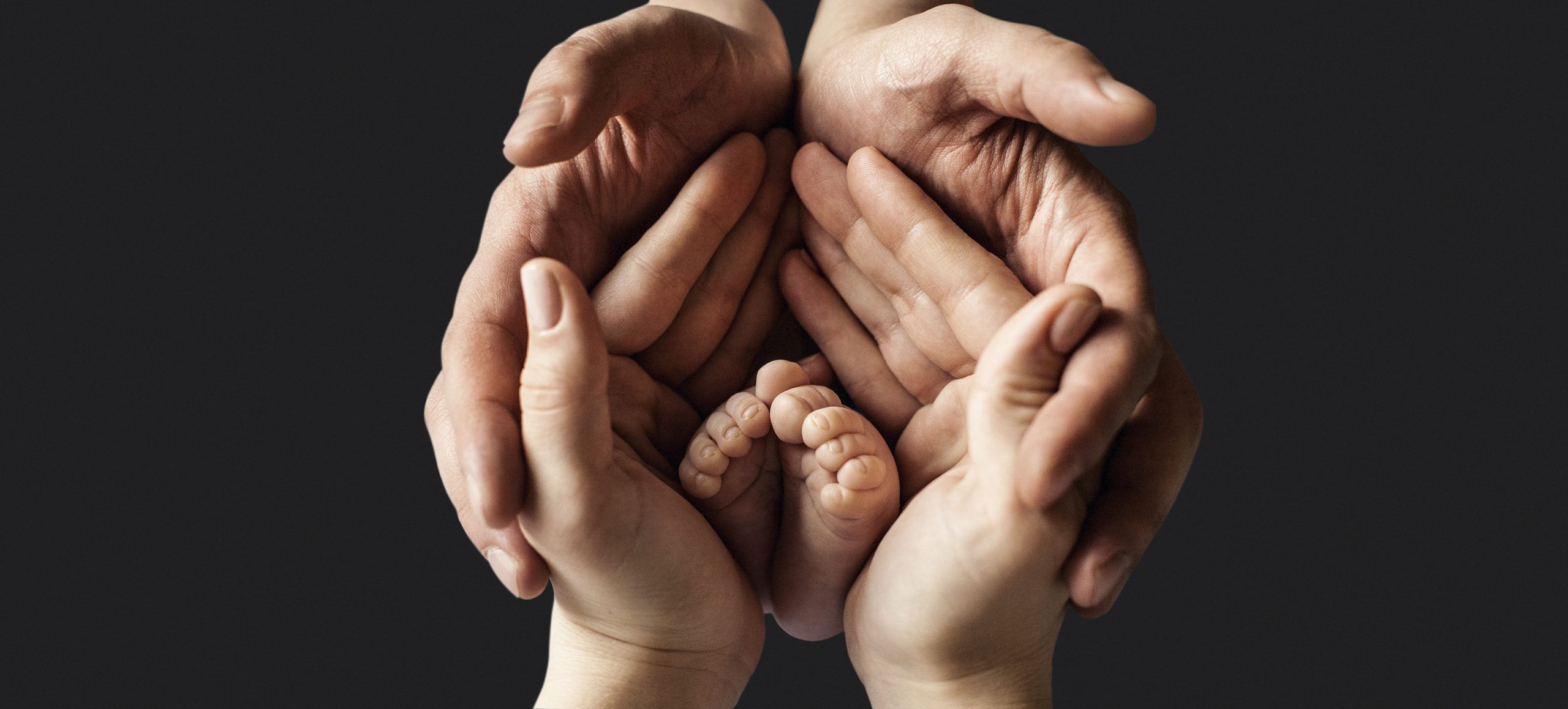Little child foot in parents palms